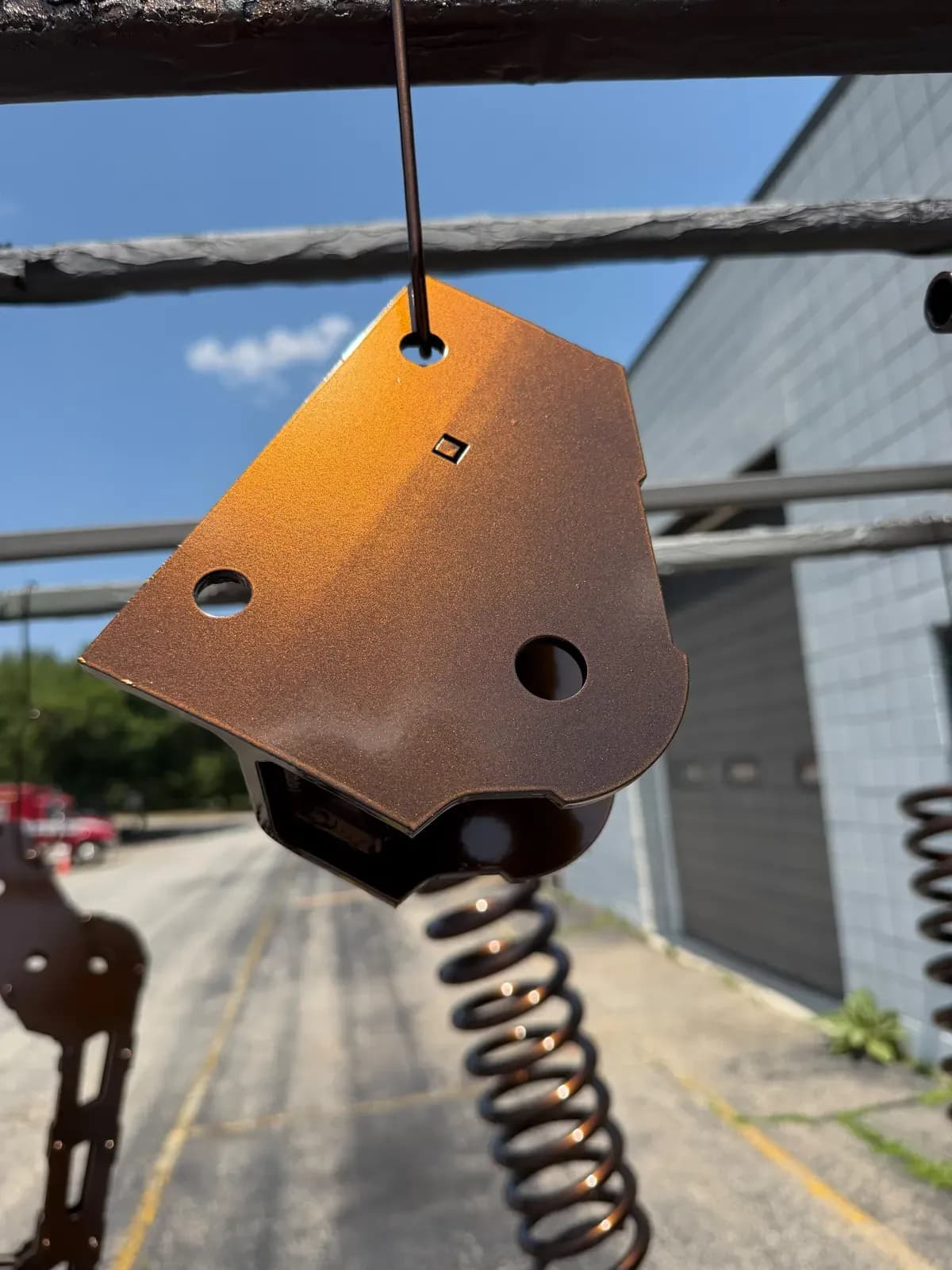 Orange powder coated bracket with a bronze spring