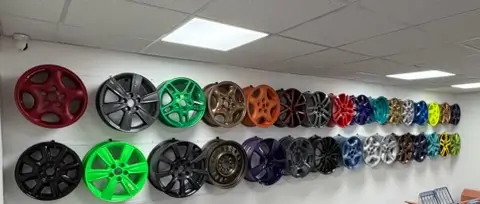 Wall of sample wheels in different powder coat colors