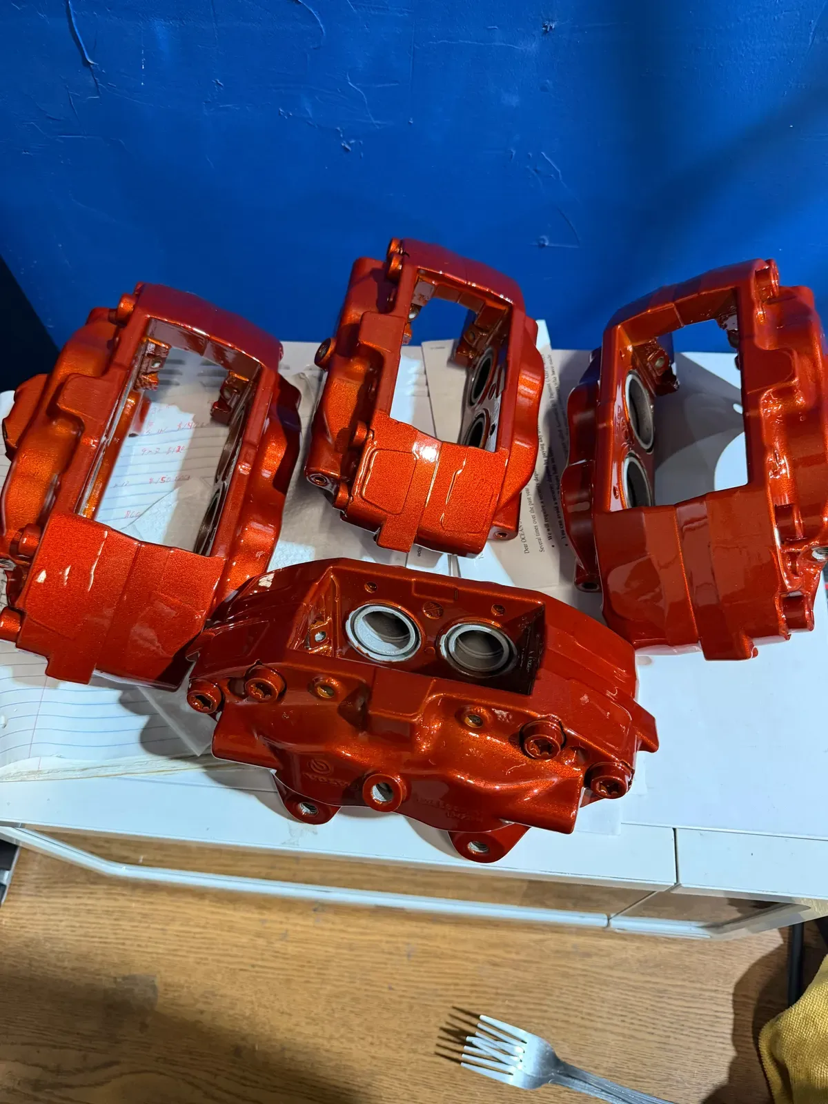 Set of brake calipers powder coated in red orange at the shop