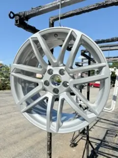 Silver powder coated alloy wheel hanging outside the shop