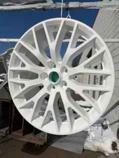 White powder coated alloy wheel hanging on the rack