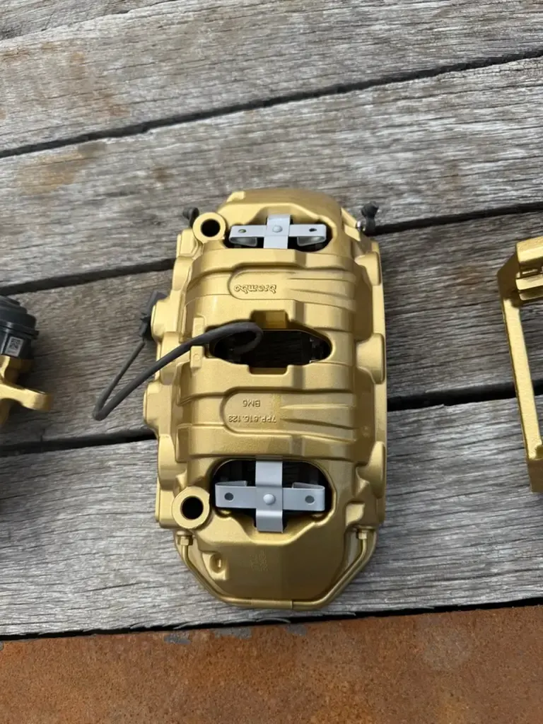 Red powder coated brake caliper behind an open-spoke alloy wheel